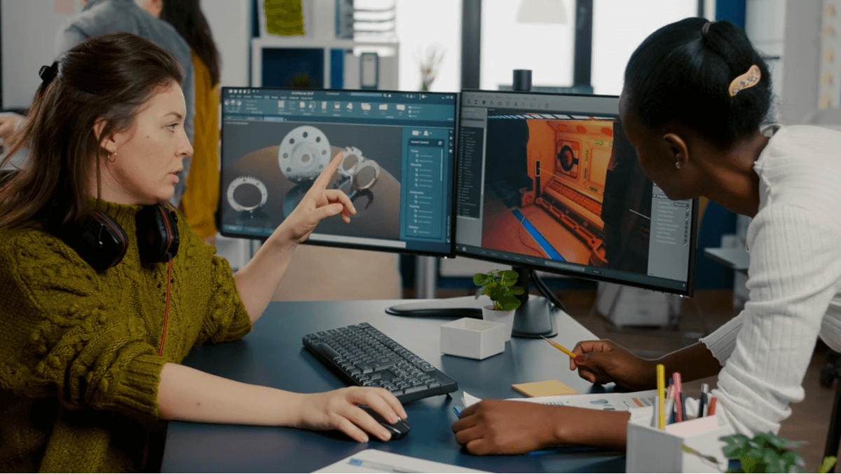 two women discuss content displayed across two screens